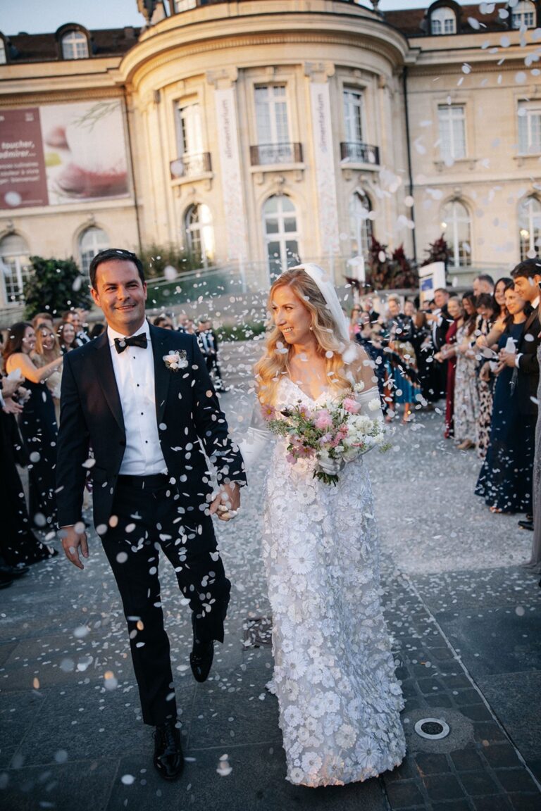 Couple leaving the ceremony through guests throwing petals before a château facade, Daria Events and Weddings