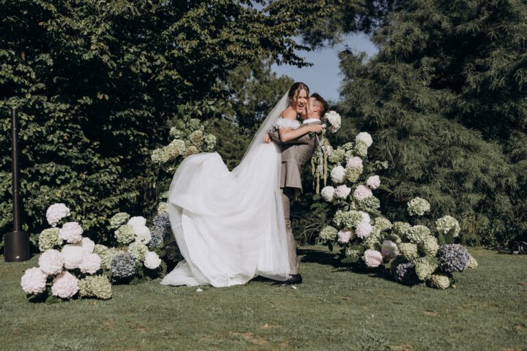 Couple among hydrangea arrangements at an outdoor ceremony, Hotel Royal Evian, France, Daria Events and Weddings