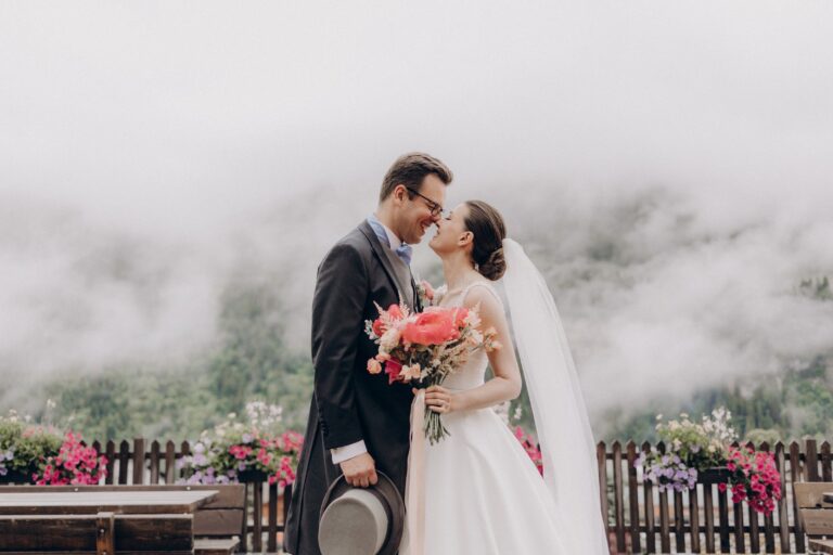 Couple embracing on a flower-lined balcony in the mountain mist, Champéry, Switzerland, Daria Events and Weddings