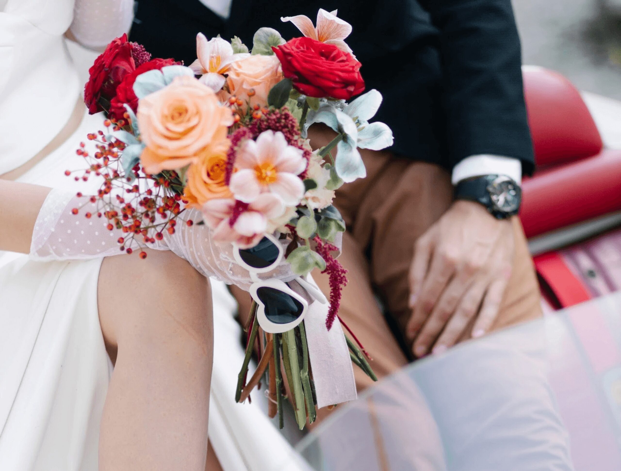Bridal bouquet of roses and berries held beside a vintage car, Daria Events and Weddings