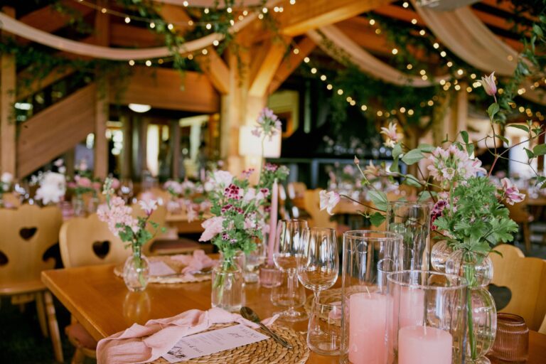 Reception hall with timber beams, fairy lights and floral table settings, Daria Events and Weddings