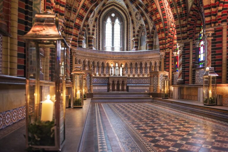 The chapel's banded arches and tiled floor lit by lanterns and candles, De Vere Horsley Estate
