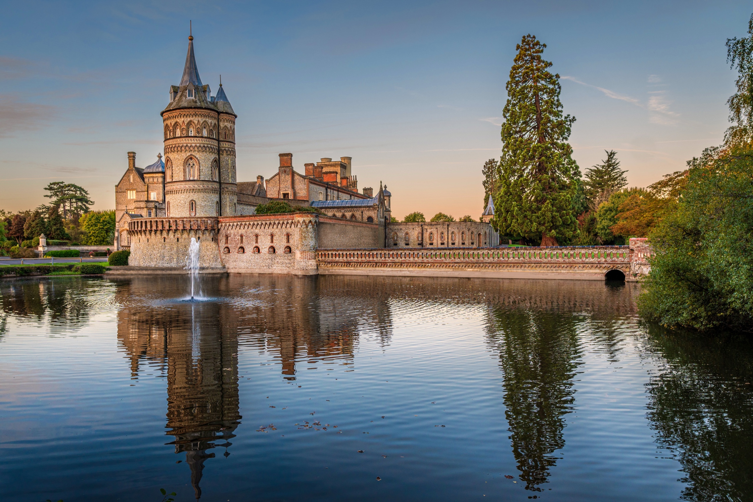 Horsley Towers and the Italian tower reflected in the lake at dusk, with the fountain playing, De Vere Horsley Estate