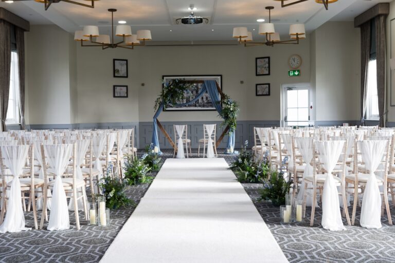A ceremony room with an aisle and floral arch, De Vere Wokefield Estate