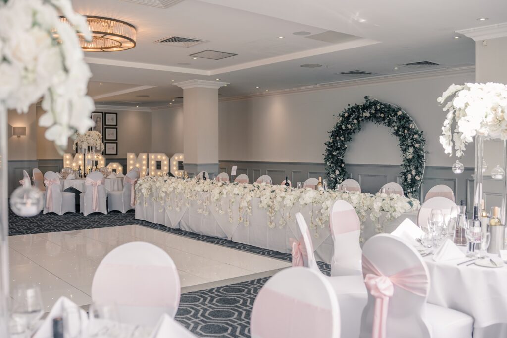 A top table with a floral arch and lettering, De Vere Wokefield Estate
