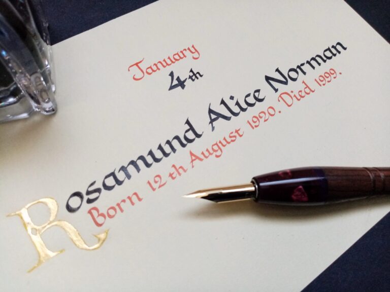A memorial book entry in calligraphy with a gilded initial and a fountain pen, Denise Hagon Calligrapher