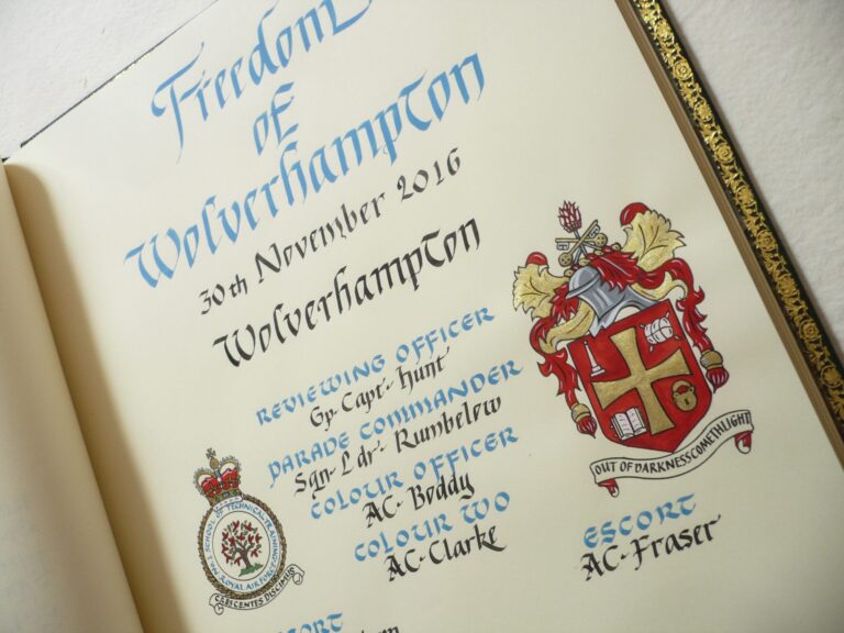A civic honours book entry in blue and black calligraphy with heraldic painting, Denise Hagon Calligrapher