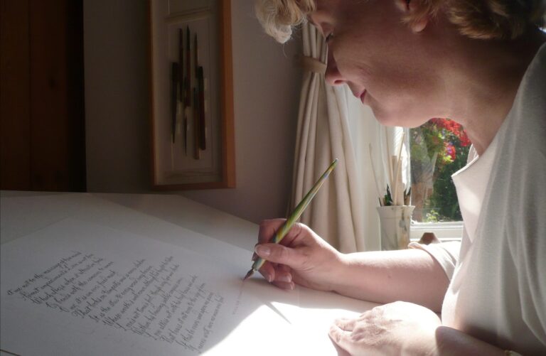 Denise Hagon writing calligraphy with a dip pen at her desk, Denise Hagon Calligrapher