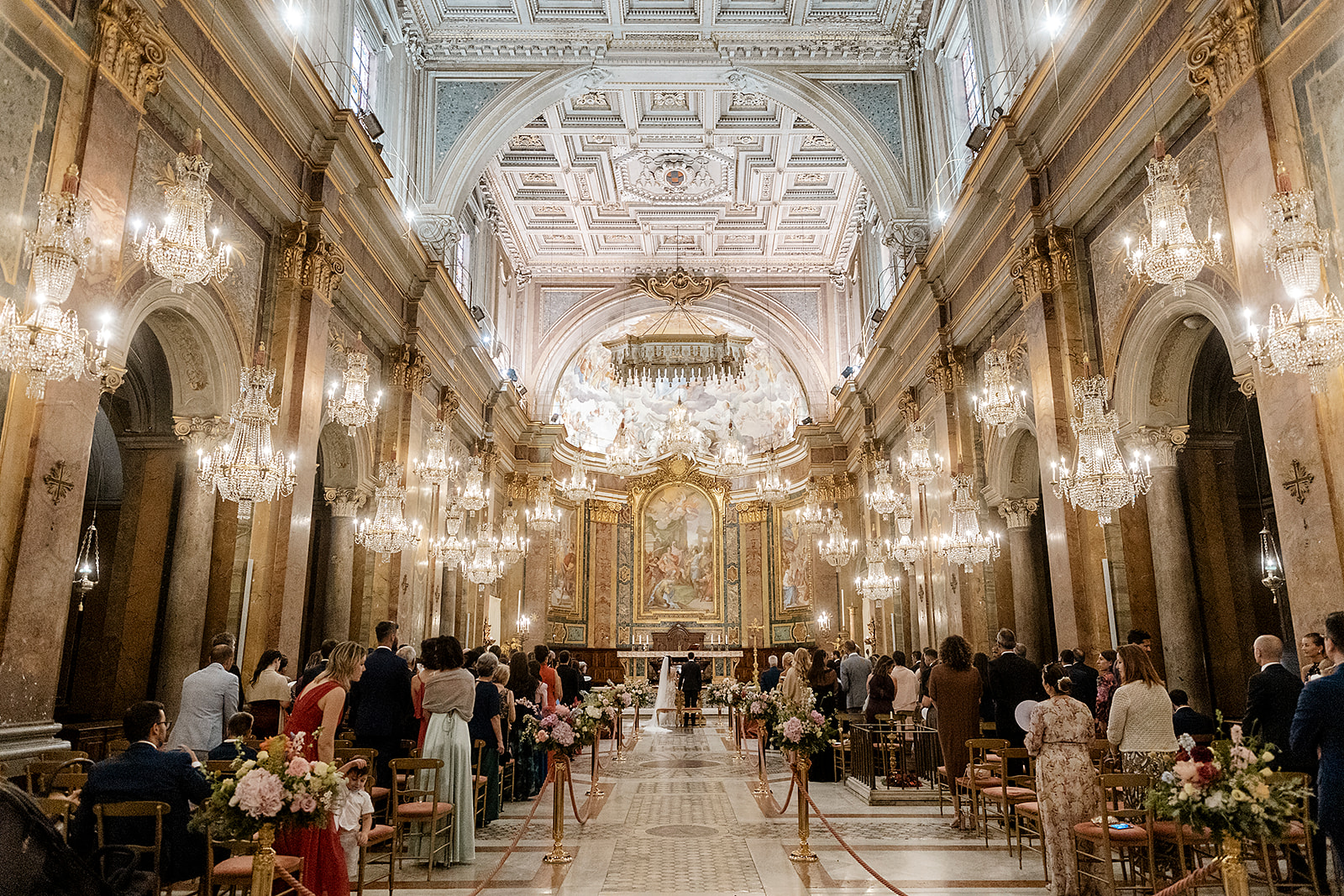 A wedding ceremony in the Basilica dei Santi Giovanni e Paolo, Rome, under its rows of crystal chandeliers, Denise More