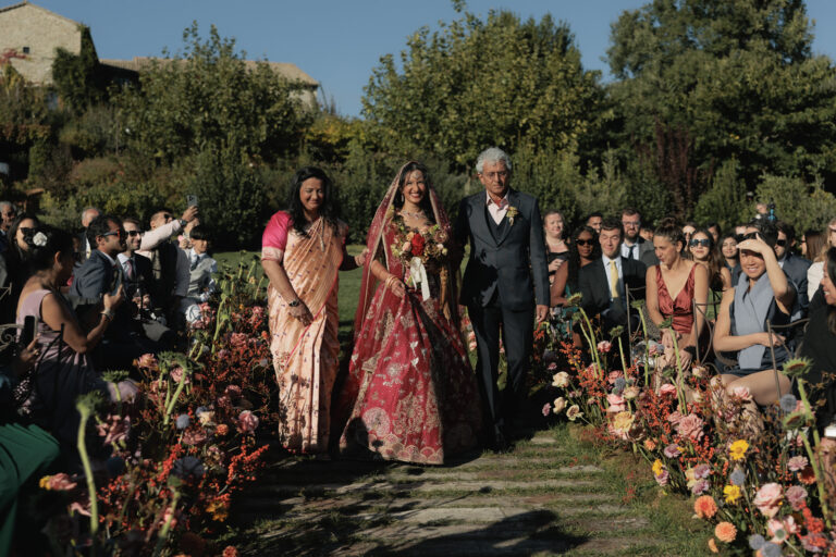 The bride's procession down a flower-lined aisle at Castello di Petrata, Umbria, Denise More