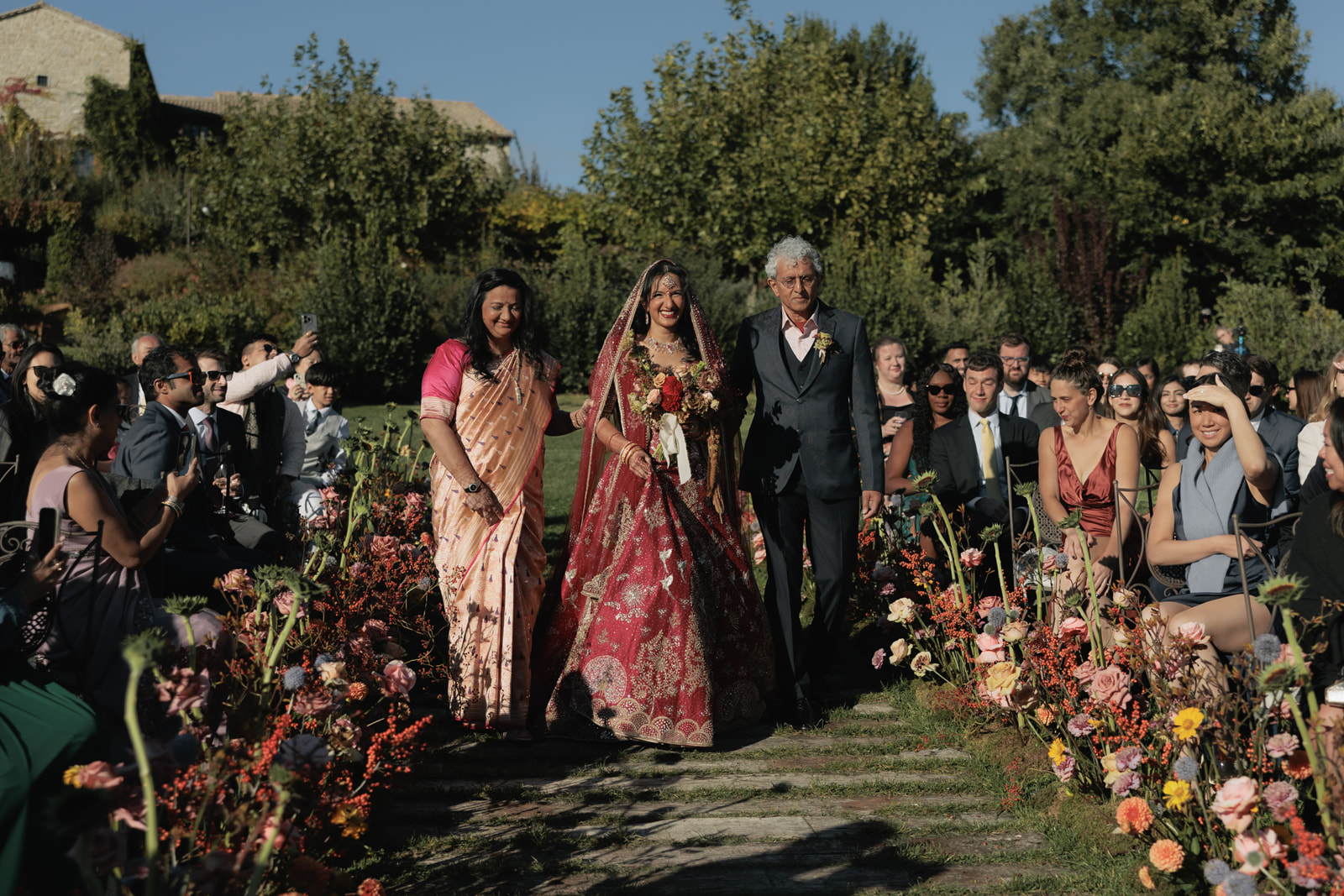 The bride's procession down a flower-lined aisle at Castello di Petrata, Umbria, Denise More