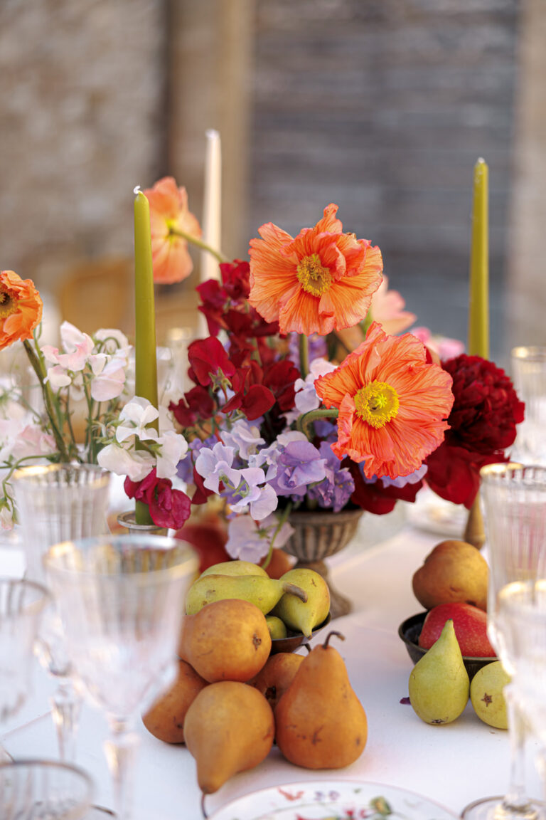 Poppies, ranunculus and pears on a dinner table in Tuscany, Denise More