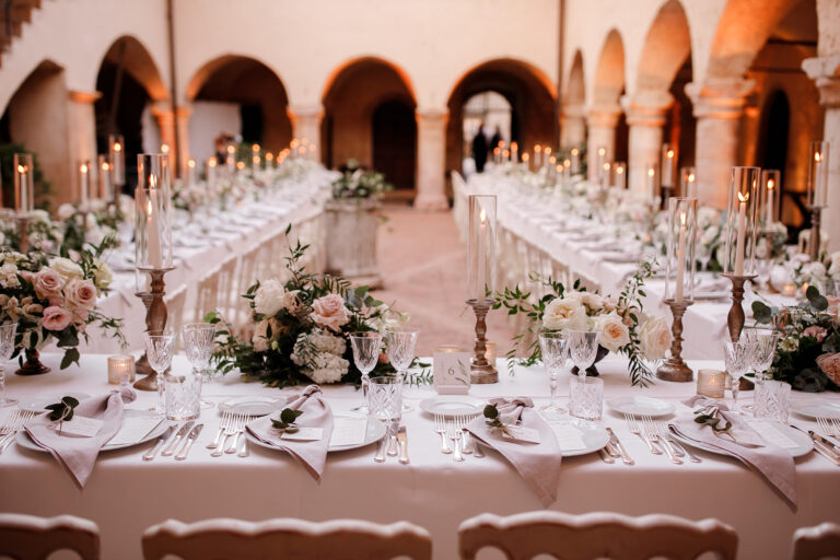 Candlelit long tables under the arches of the cloister at the Abbazia di San Pietro in Valle, Umbria, Denise More