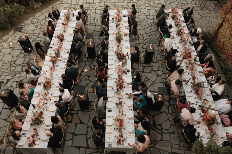 Overhead view of guests at long tables in the stone courtyard at Castello di Petrata, Umbria, Denise More