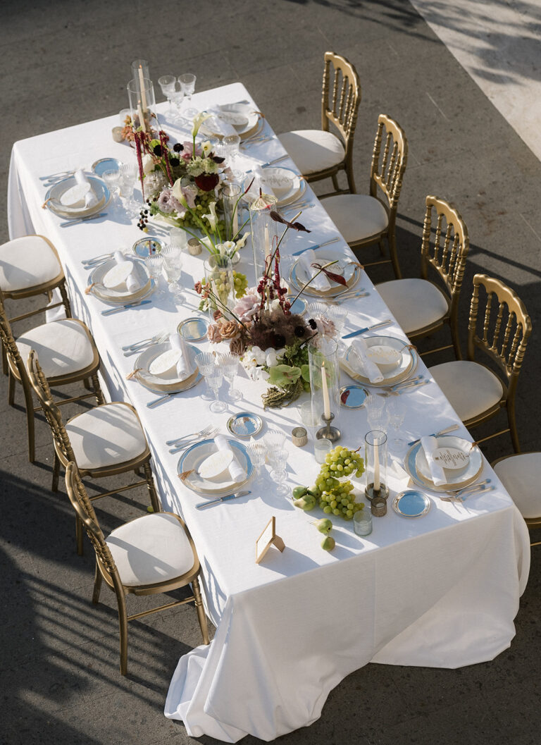 A long table with gilt chairs and dark red flowers on the terrace at Villa Miani, Rome, Denise More