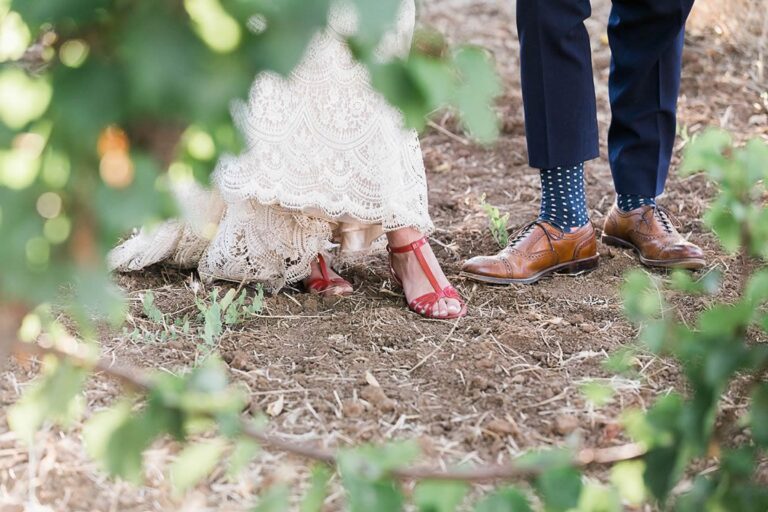 Bridal shoes and the groom's brogues on an earthen path among leaves, Despina Craig Events