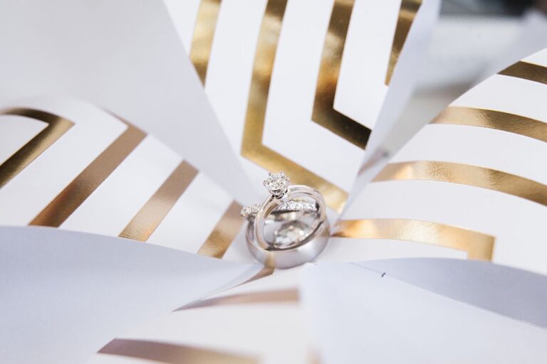 Wedding rings set in the fold of a gold and white paper pinwheel, Despina Craig Events