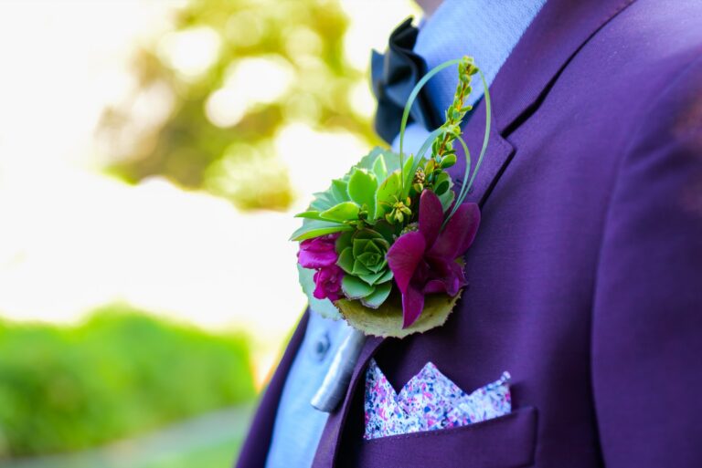 A succulent and orchid boutonniere on a plum suit with a patterned pocket square, Despina Craig Events