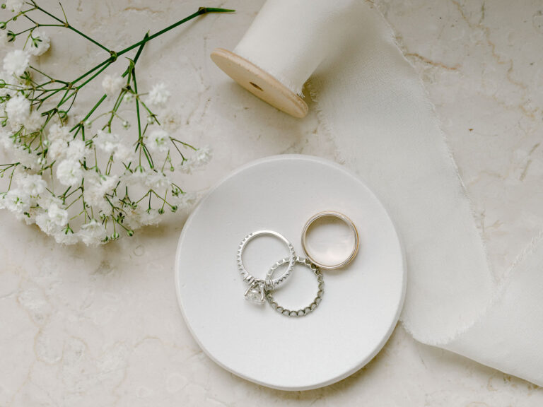 Wedding rings on a small dish with gypsophila and ribbon. Sam and Lance's elopement on Garda Island, Lake Garda, Detito Photography