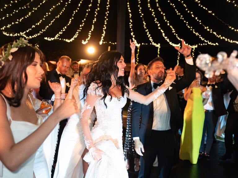 The bride dancing with guests under strings of lights. Alex and Andrew's wedding at Villa Cimbrone, Ravello, Amalfi Coast, Detito Photography
