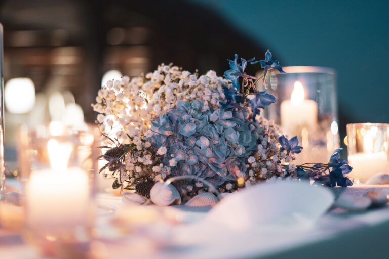 Blue hydrangea, gypsophila and candles on a seaside dinner table scattered with shells, Diamante Your Wedding in Italy