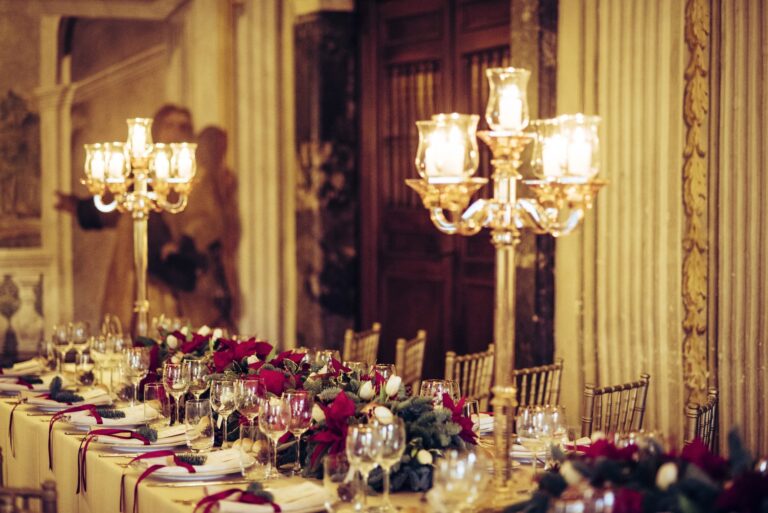 Crystal candelabra and a runner of poinsettias and white tulips along a winter dinner table, Diamante Your Wedding in Italy