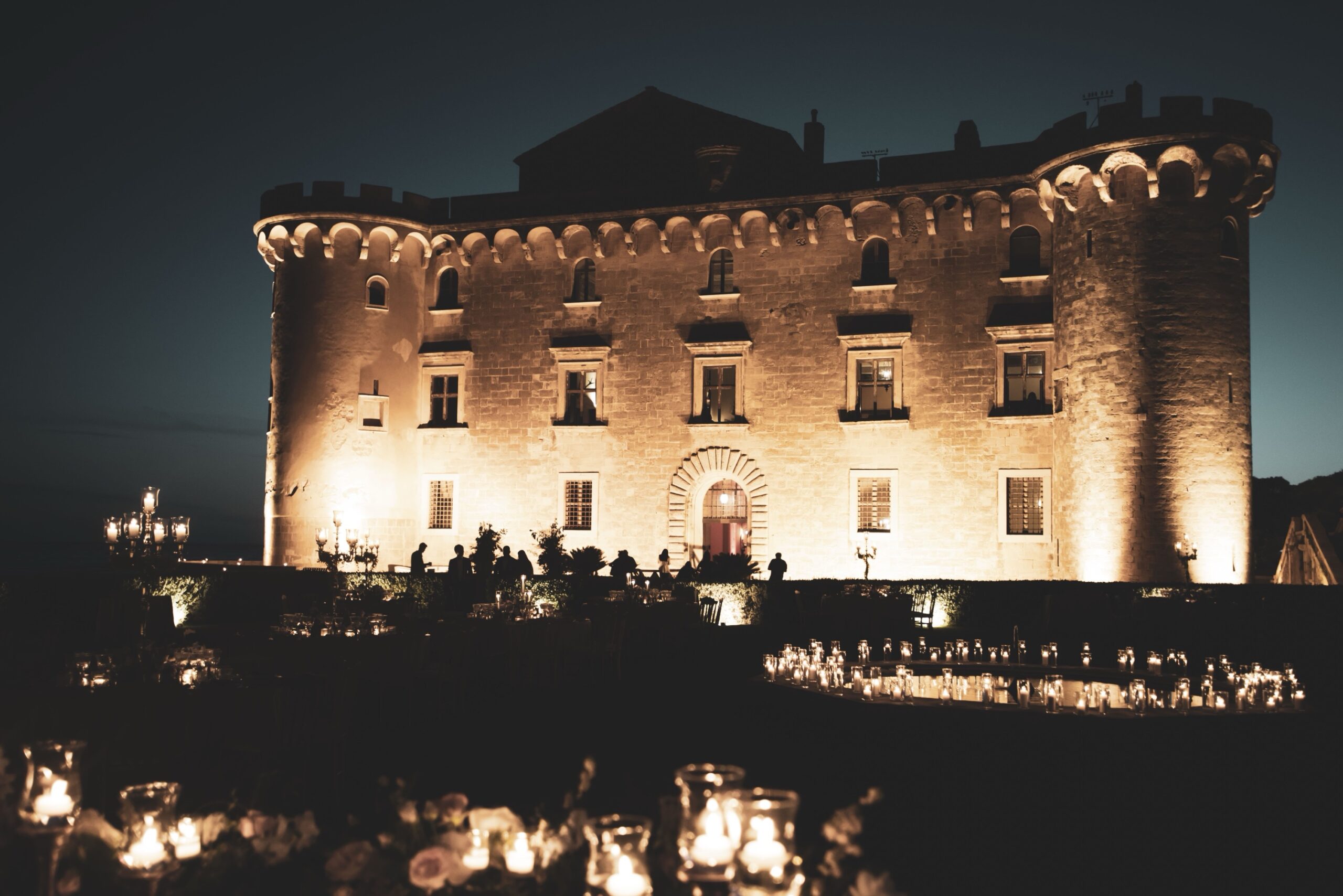 The Castle of Palo floodlit at night, with candles along the terrace below, Diamante Your Wedding in Italy