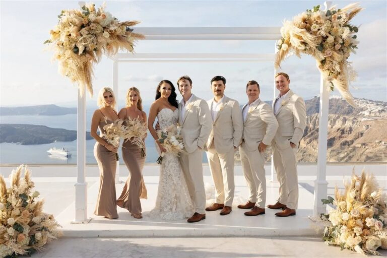 A wedding party beneath a dried floral arch at Santorini Gem, Diamond Rock Santorini