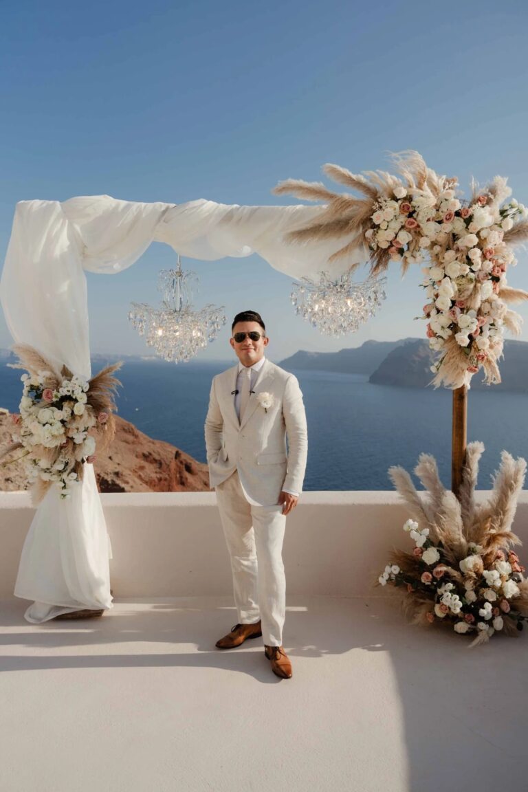 A groom at a pampas and floral arch at Love Cave Venue, Santorini, Diamond Rock Santorini
