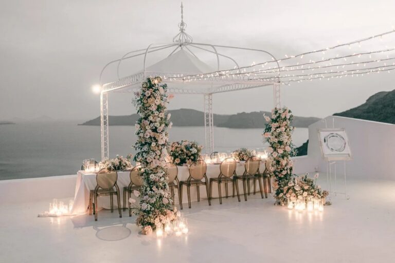 A long candlelit table with floral columns at the Diamond Rock Venue, Santorini, Diamond Rock Santorini