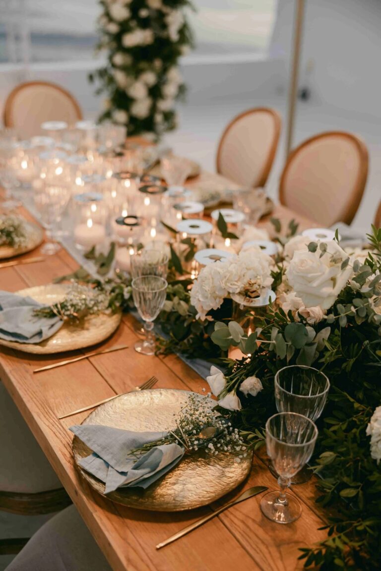 A wooden banquet table with white florals at the Diamond Rock Venue, Santorini, Diamond Rock Santorini