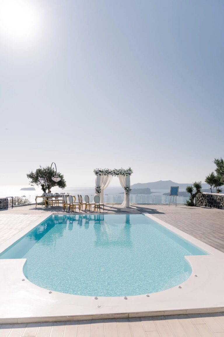 A pool terrace with a floral ceremony arch at Thermes, Santorini, Diamond Rock Santorini
