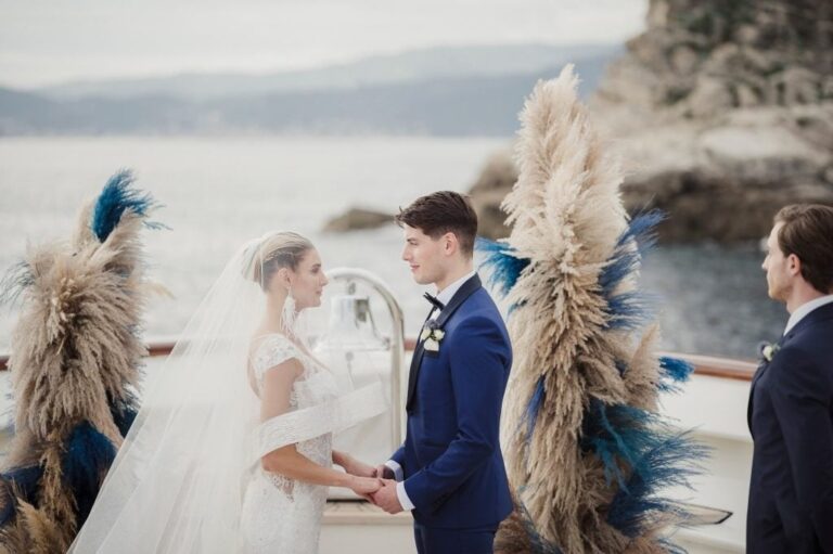 Holding hands at a seaside ceremony, framed by pampas grass, Diego Giusti Photographer