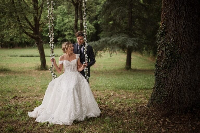 Bride and groom on a flower-draped swing in the woods, Diego Giusti Photographer