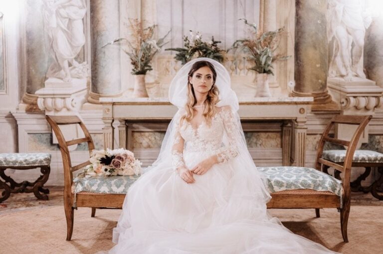 A bride seated in a frescoed palazzo room, veil framing her face, Diego Giusti Photographer