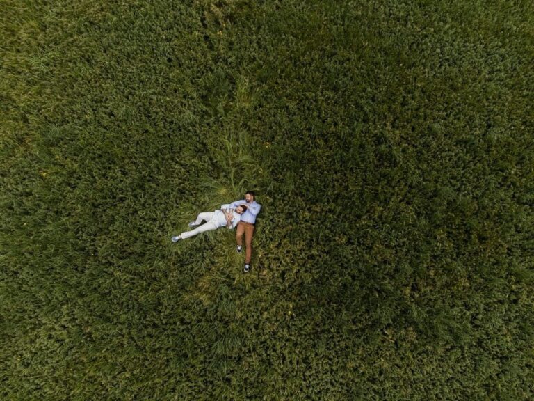 Seen from directly above, a couple lying in a field of grass, Diego Giusti Photographer