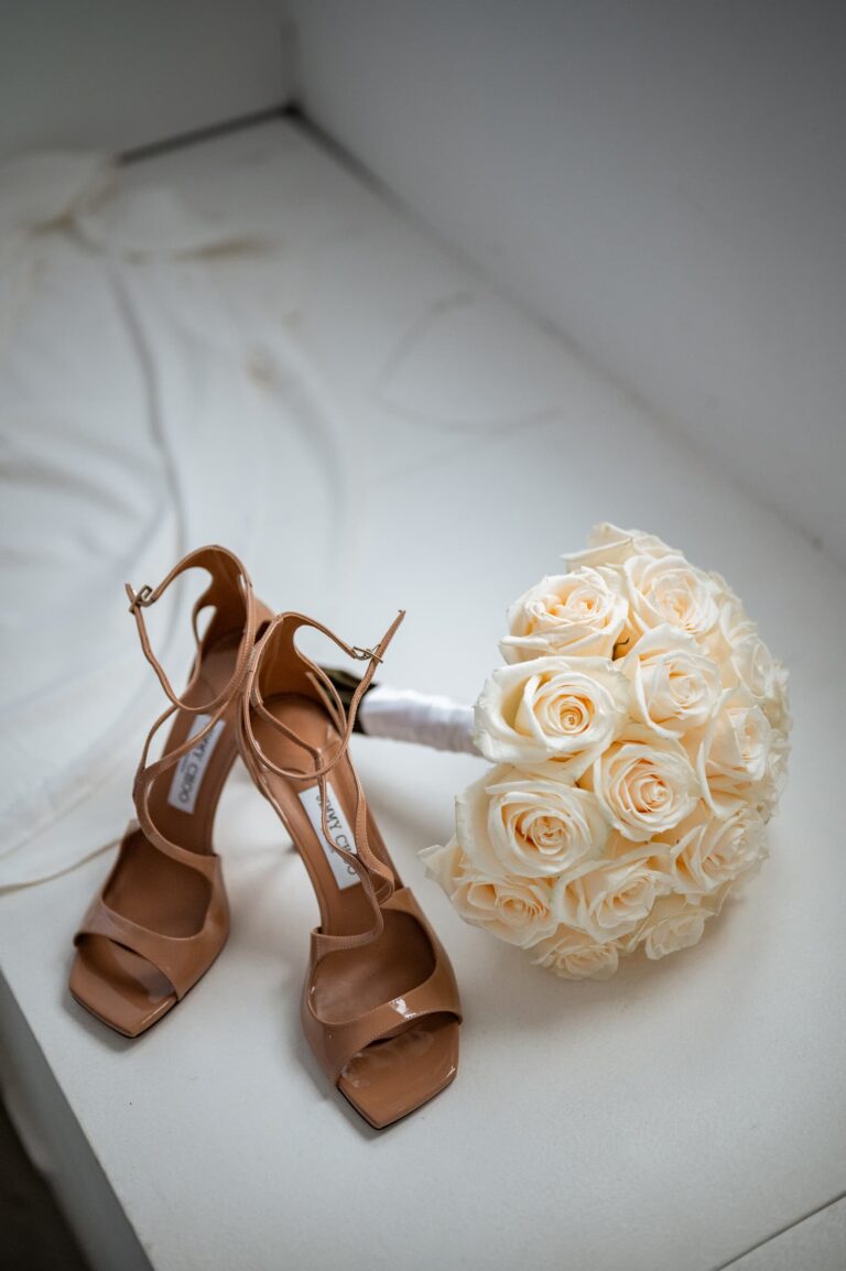 The bridal shoes and a white rose bouquet on the bed, Dimas Frolov Photography