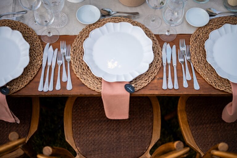 A dinner table set with woven placemats and scalloped plates, seen from above, Dimas Frolov Photography