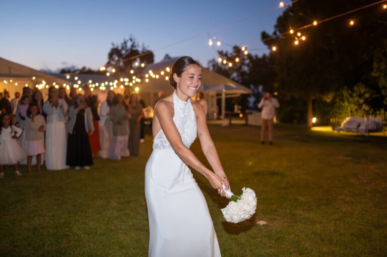 The bride tosses her bouquet on the lawn at dusk, Casal do Frade, Sesimbra, Dimas Frolov Photography