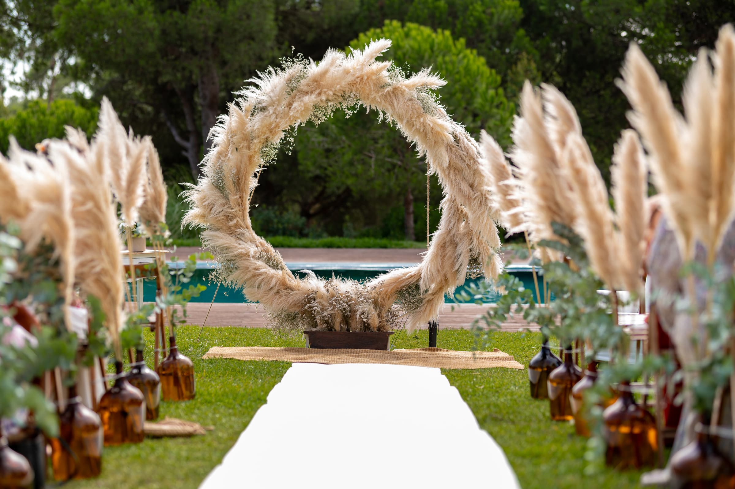 A circular pampas arch at the end of the aisle, beside the pool at Casal do Frade, Sesimbra, Dimas Frolov Photography