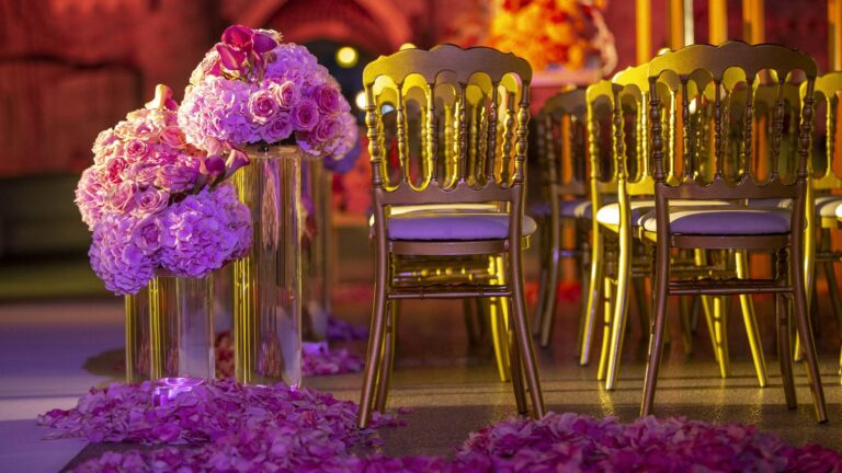 Gold chairs and pink and purple flowers at a castle wedding, Disneyland Paris
