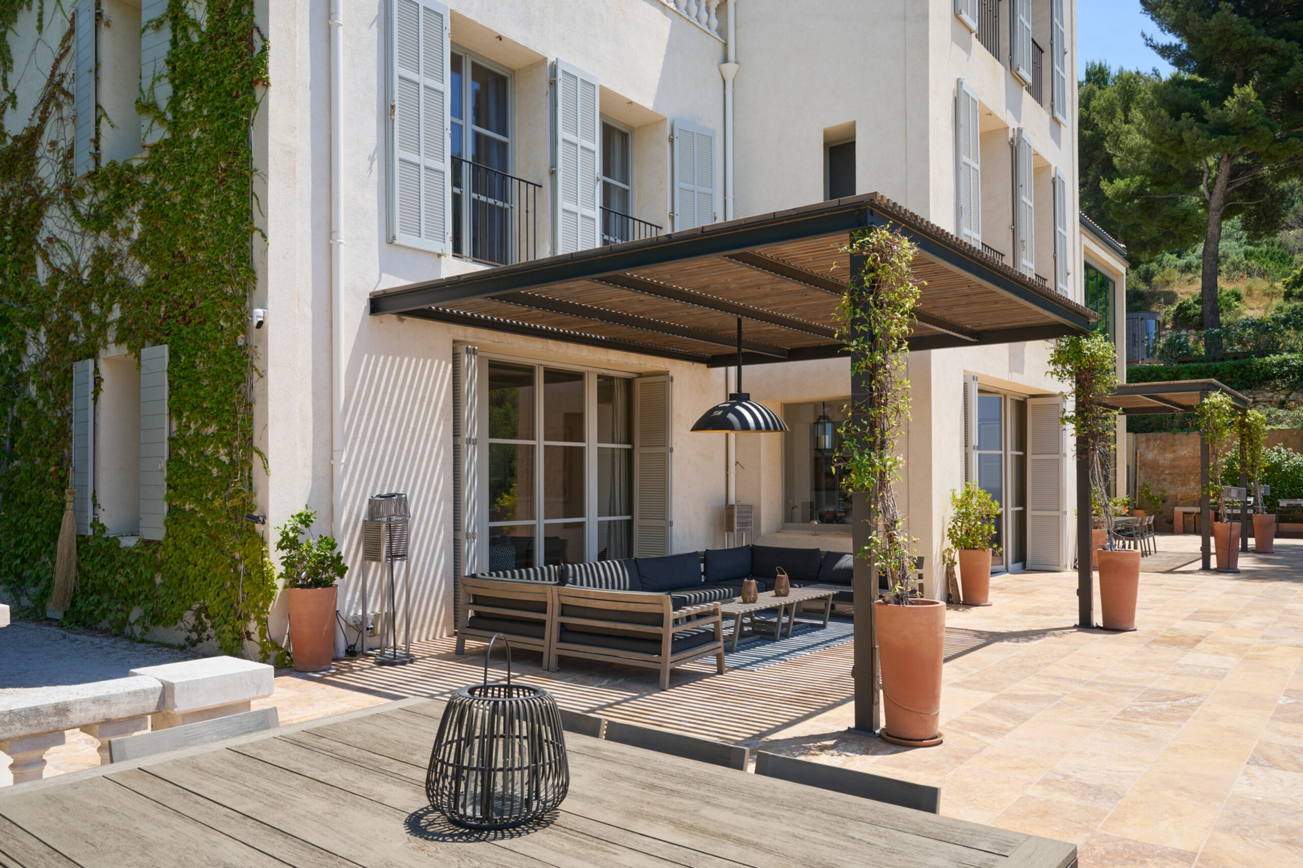 The villa facade, wrapped in ivy, and the covered terrace, Domaine de Canaille
