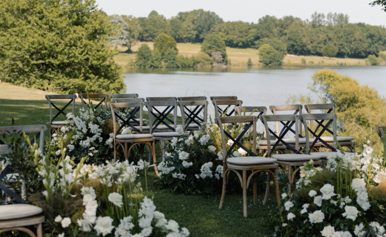 Ceremony chairs and flowers with the lake behind, Domaine des Etangs, Auberge Collection