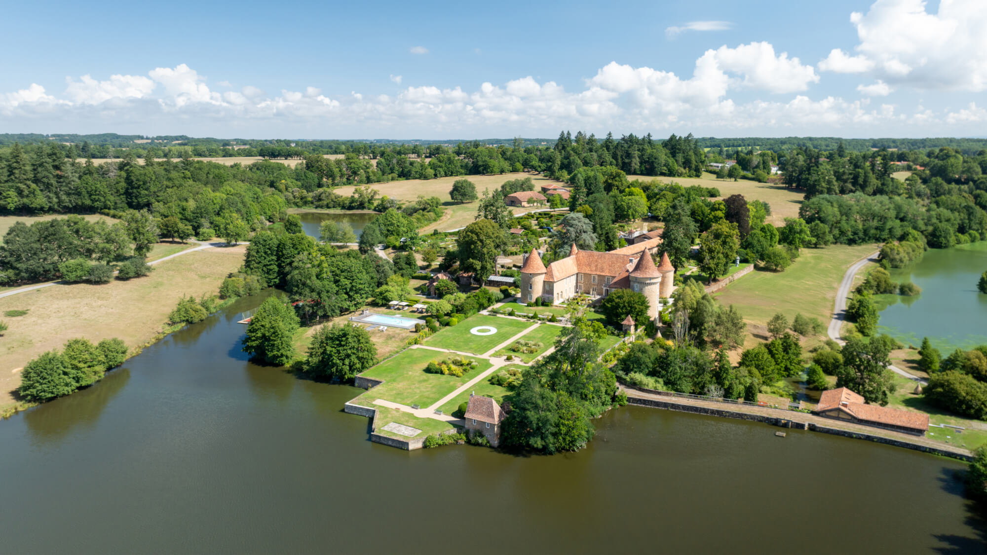 The château and its gardens beside the lake from above, Domaine des Etangs, Auberge Collection