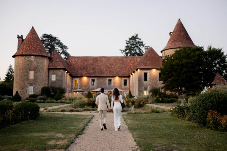 A couple walking toward the château at dusk, Domaine des Etangs, Auberge Collection