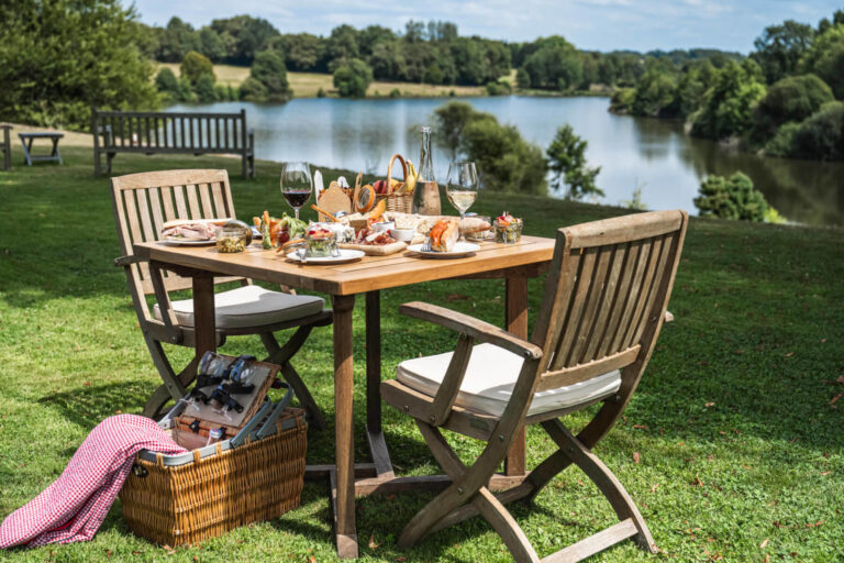 A picnic table set beside the lake, Domaine des Etangs, Auberge Collection