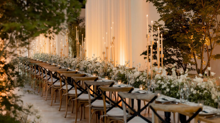 Long wedding table with flowers and candles in La Laiterie, Domaine des Etangs, Auberge Collection