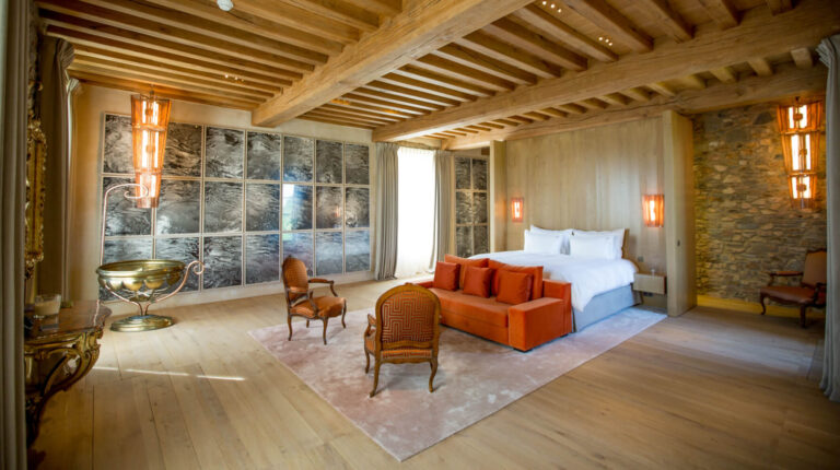 A château suite with timber ceiling and stone walls, Domaine des Etangs, Auberge Collection