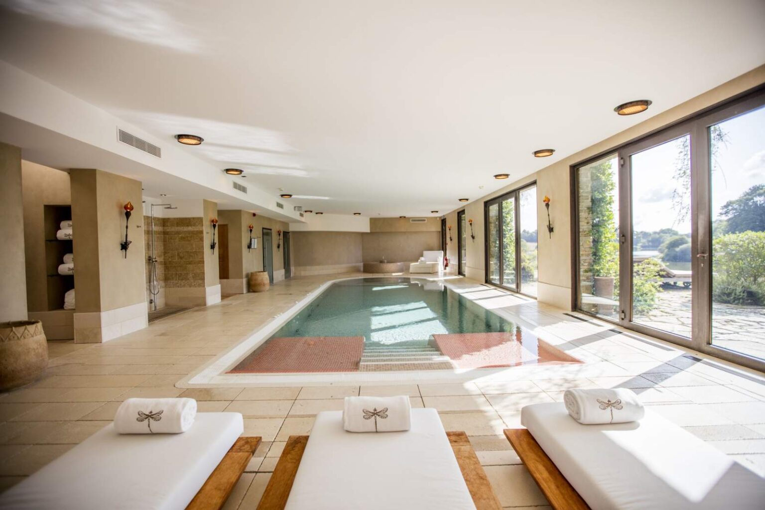 The indoor pool with loungers and lake views