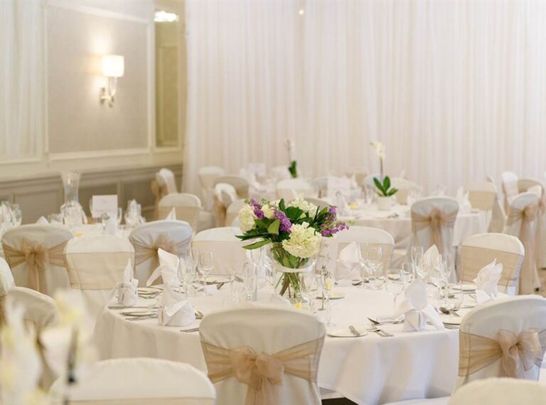 Round tables laid with white linen and flowers, Down Hall Country House Hotel
